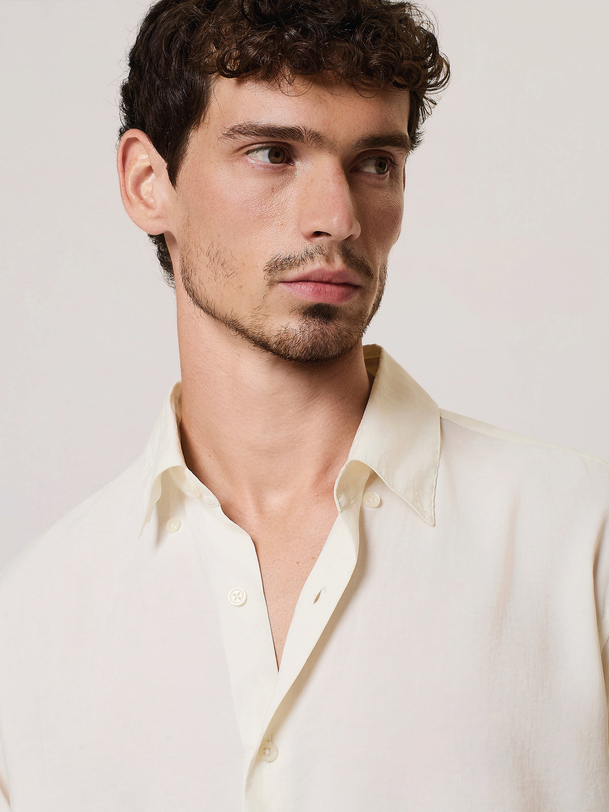 Dettaglio camicia da uomo bianca con fondo arrotondato e costruzione fluida, David Naman